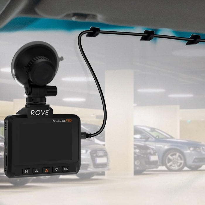 Car dashboard adhesive cable clip holding a black wire near dash camera