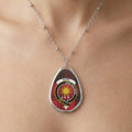 Close-up of Kerr pendant necklace with crest design