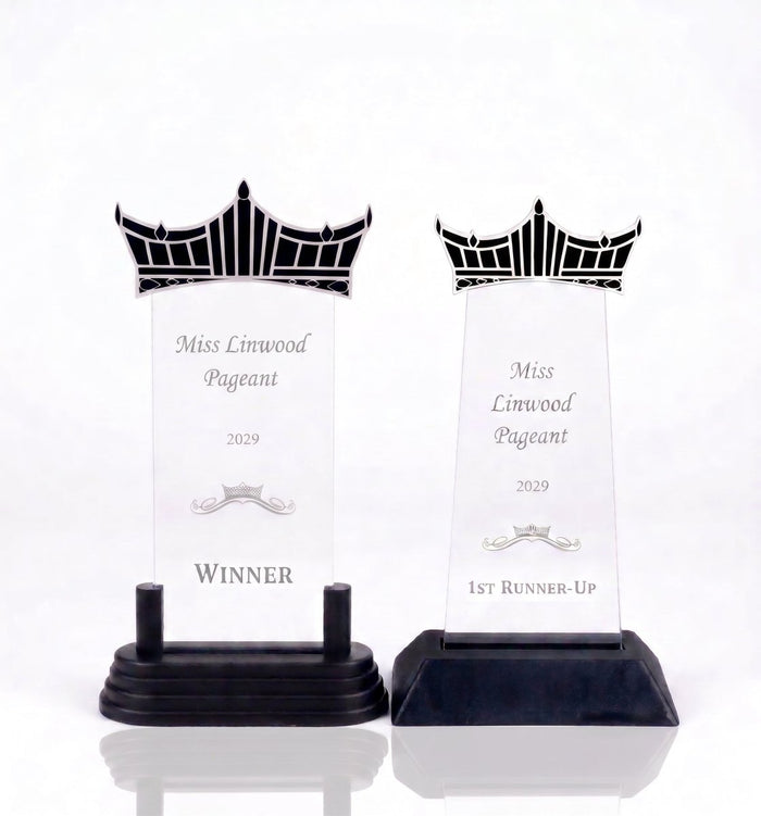 Two acrylic award plaques on black bases, both featuring a crown design (AI Generated)